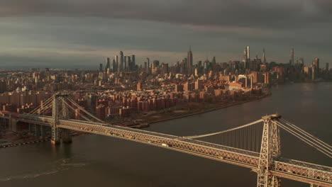 Dolly-back-reveal-aerial-shot-of-the-Williamsburg-Bridge-East-river-with-the-Manhattan-skyline-in-the-background