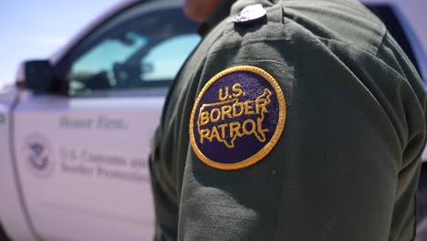 Border-patrol-agent-standing-next-to-unit