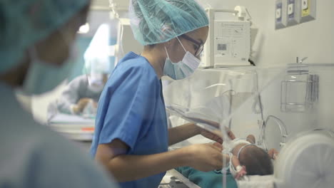 Arzt-Behandelt-Neugeborenes-Im-Inkubator