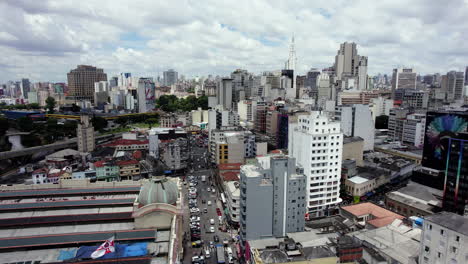 Aerial-view-overlooking-streets-and-buildings-in-sunny-downtown-Sao-Paulo,-Brazil---Ascending,-pan,-drone-shot