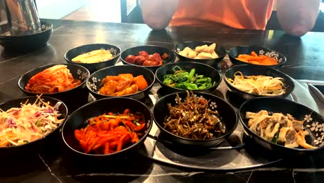 Korean-style-condiments-and-side-dishes-being-placed-on-the-table
