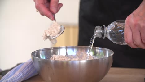 Mixing-different-ingredients-in-the-kitchen-in-a-bowl-to-prepare-the-dough