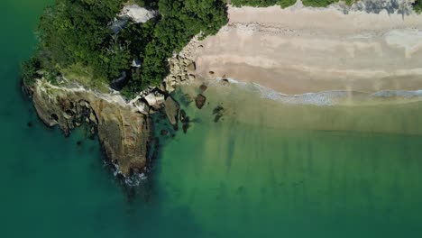 Aerial-view-of-isolated-hidden-beach-on-summers-day-with-rocky-cove