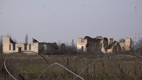 A-murder-of-Crows-fly-over-destroyed-buildings-in-Posad-Pokrovs’ke-village,-the-centre-of-the-most-fierce-fighting-between-Ukrainian-and-Russian-troops-at-the-start-of-the-war