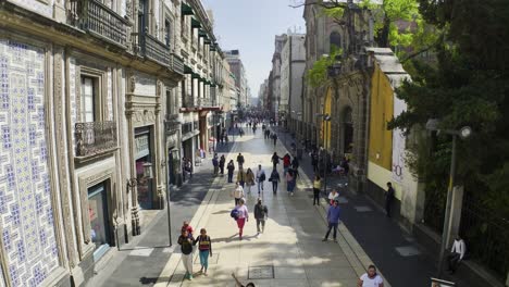 Aerial-view-low-over-people-on-Madero-Pedestrian-Street,-in-sunny-Mexico-city