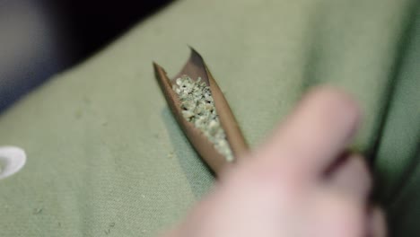 close-up-blunt-cigar-roll-full-of-marijuana-weed-drug-being-held-by-male-hand