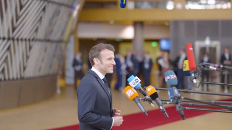 El-Presidente-Francés-Emmanuel-Macron-Hace-Una-Declaración-De-Prensa-En-El-Edificio-Del-Consejo-Europeo-En-Bruselas,-Bélgica---Banderas-De-La-Ue-En-Segundo-Plano