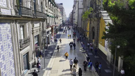 Ascending-aerial-view-of-tourists-walking-on-the-Madero-Street,-in-Mexico-city