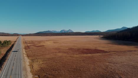 4k-Drone-Retrocede-Lentamente-Sobre-Campo-Abierto-En-Las-Montañas-De-Dientes-De-Sierra,-Stanley-Idaho