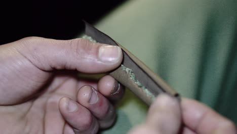 4K-Männchenhände-Halten-Reinen-Weed-Haze-stumpfen-Joint-In-Zeitlupen-Zigarrenpapier,-Bereit-Zum-Aufrollen