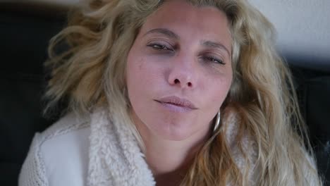 Close-up-of-a-sick-woman-resting-as-she-briefly-opens-her-eyes