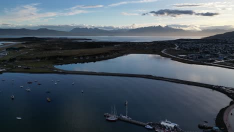 Patagonian-Bay-Landscape-in-Ushuaia-Argentina,-Aerial-Drone-Fly-Above-Port-Sea-Water-and-Natural-Mountain-Range-Skyline-of-Antarctic-Gateway-City