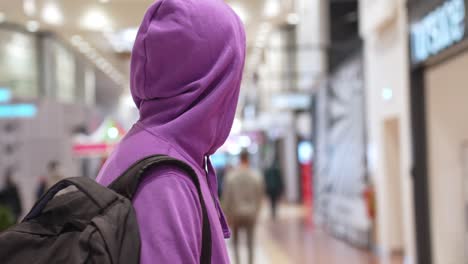 Young-hooded-modern-Indian-man-pensive-looking-in-a-shopping-mall