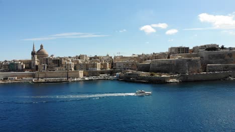 Luxury-yacht-in-mediterranean-capital-city,-blue-sea-harbour-Valletta,-Malta-on-hot-summer-day