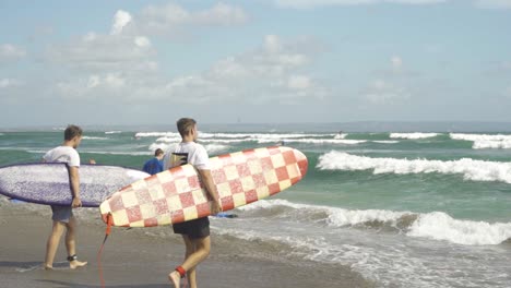 Surfistas-Caminando-Hacia-Las-Olas-En-La-Playa-De-Batu-Bolong-En-Bali-Canggu