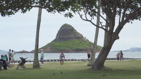 Tourist-Enjoy-an-Overcast-Day-at-the-Beach-Looking-on-to-the-Island-of-Mokoli'i-Also-Known-as-Chinaman's-Hat
