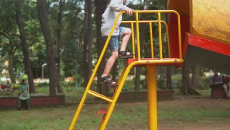 Happy-child-climbing-a-big-orange-red-slide