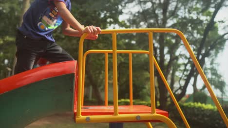 happy-child-in-the-playground-climbing-the-colourful-slide-and-then-sliding