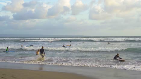 Surfistas-Disfrutando-De-Las-Olas-Nocturnas-Antes-Del-Atardecer-En-La-Playa-De-Batu-Bolong-En-Bali-Canggu,-Un-Destino-Famoso-Para-Los-Nómadas-Digitales-De-Todo-El-Mundo