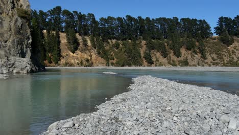 Gently-flowing-river-winds-through-gorge-on-a-clear-summer's-day---Waimakariri-River-Gorge
