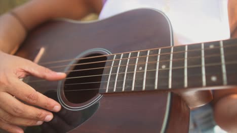 Slowmotion-close-up-shot-during-to-the-hands-of-a-girl-playing-the-guitar-during-sunset