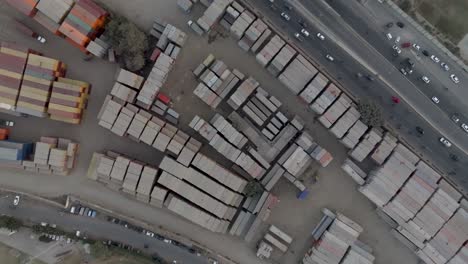 Aerial-Birds-Eye-View-Of-Dusty-Stacked-Cargo-Containers-At-Storage-Site-In-Karachi