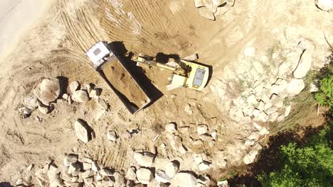 Excavator-Removing-Sand-Into-Dump-Truck-Top-View