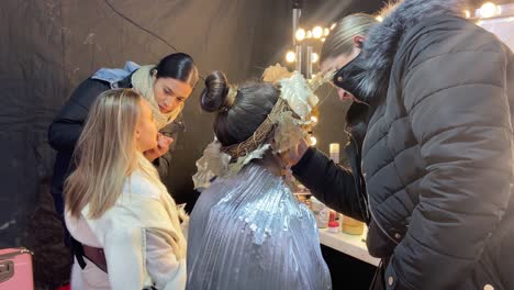 Two-make-up-artists-applying-make-up-to-two-young-girls-in-carnival-costumes
