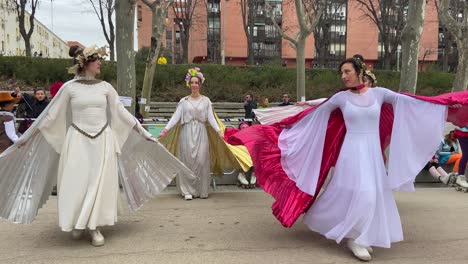 Front-view-of-group-of-dancers-in-fairy-costumes-practicing-carnival-choreography-in-the-street