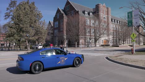 Berkey-Hall-En-El-Campus-De-La-Universidad-Estatal-De-Michigan-Con-Un-Coche-De-Policía-Delante-Y-Estudiantes-Caminando