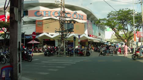 Famous-tourist-market-Cho-Con-entrance-with-parked-vehicles-and-people-crossing,-Da-Nang-city,-Vietnam