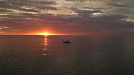 Silhouette-Segelboot-Orange-Sonnenstrahlen-Im-Meer