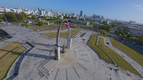 Reibungsloser-Drohnenflug-Um-Das-Denkmal-Mit-Der-Flagge-Der-Dominikanischen-Republik-In-Santo-Domingo-Bei-Sonnenuntergang---Plaza-De-La-Bandera