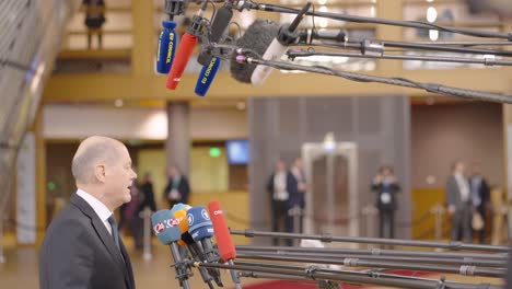 Chancellor-of-Germany-Olaf-Scholz-talking-to-the-press-in-the-European-Council-building-during-EU-summit-in-Brussels,-Belgium