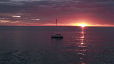 silhouette-sailboat-orange-sun-rays