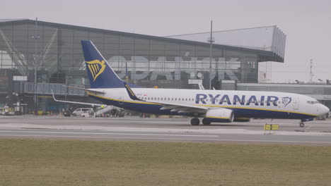 Weitwinkelaufnahme,-Kamerafahrt-Eines-Ryanair-Flugzeugs,-Das-Zur-Landebahn-Am-Flughafen-Danzig,-Polen,-Rollt