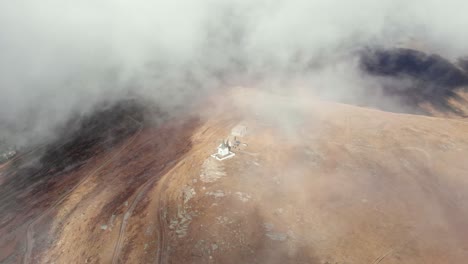 Drohnenvideo,-Absteigende-Wolken,-Gipfel,-Berg,-Kirchendenkmal,-Kaimaktsalan