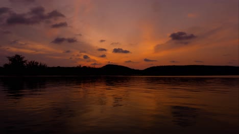 Atemberaubender-Zeitraffer-Bei-Sonnenuntergang-über-Dem-Meer-Mit-Bergen-Im-Hintergrund