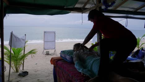 woman-enjoying-a-Thai-massage-on-the-La-Mai-beach,-Koh-Samui-island,-Thailand