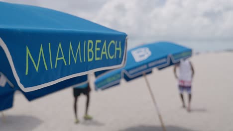 Miami-Beach-Schild-An-Sonnenschirmen-In-Zeitlupe