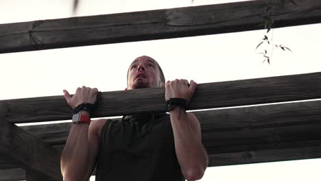 Sportsman-doing-push-ups-on-a-wooden-beam-in-a-park