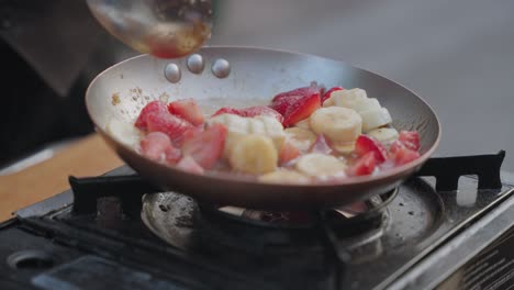 Stir-frying-banana-and-strawberries-in-slow-motion-scene