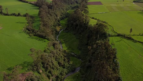 Green-field-landscape-aerial-following-the-San-Pedro-River-near-Machachi,-Ecuador