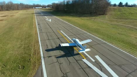 4k-Luftaufnahme,-Die-Dem-Flughafenflugzeug-Folgt,-Das-Auf-Der-Landebahn-Eines-Kleinen-Flugzeugs-Rollt