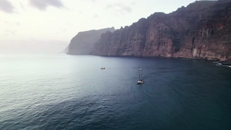 Aerial-high-angle-of-sailboat-float-near-Los-Gigantes-cliff-coast-in-Tenerife