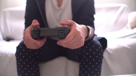 Woman's-hands-using-gamepad-close-up-view-playing-video-console-game-at-home-sitting-on-the-sofa