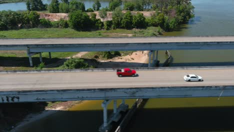 Aerial-of-cars-driving-on-bridge-that-crosses-over-the-San-Jacinto-River-in-Houston,-Texas