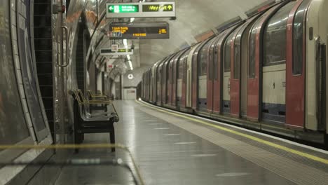 Tren-De-Metro-De-La-Línea-Central-De-Londres-Que-Sale-De-Una-Estación-Vacía