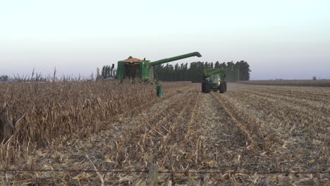 Tractor-approaches-a-combine-on-a-harvested-corn-field