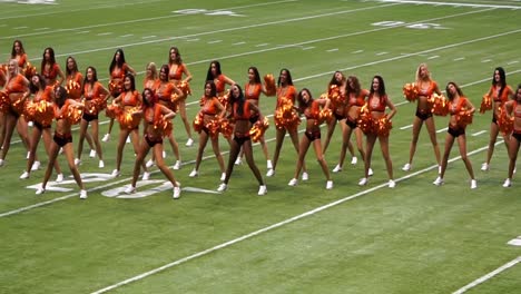 BC-Stadium-Lions-Felions-Cheerleaders-in-center-field-cheering-indoors-with-a-closed-ceiling-during-the-half-time-dance-routine-with-gold-orange-pom-poms-black-booty-mini-shorts-toned-abs-looped-video